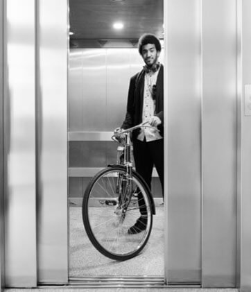 Man on a bike waiting on an elevator