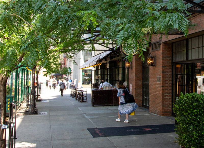 Busy city sidewalk lined with restaurants and retail